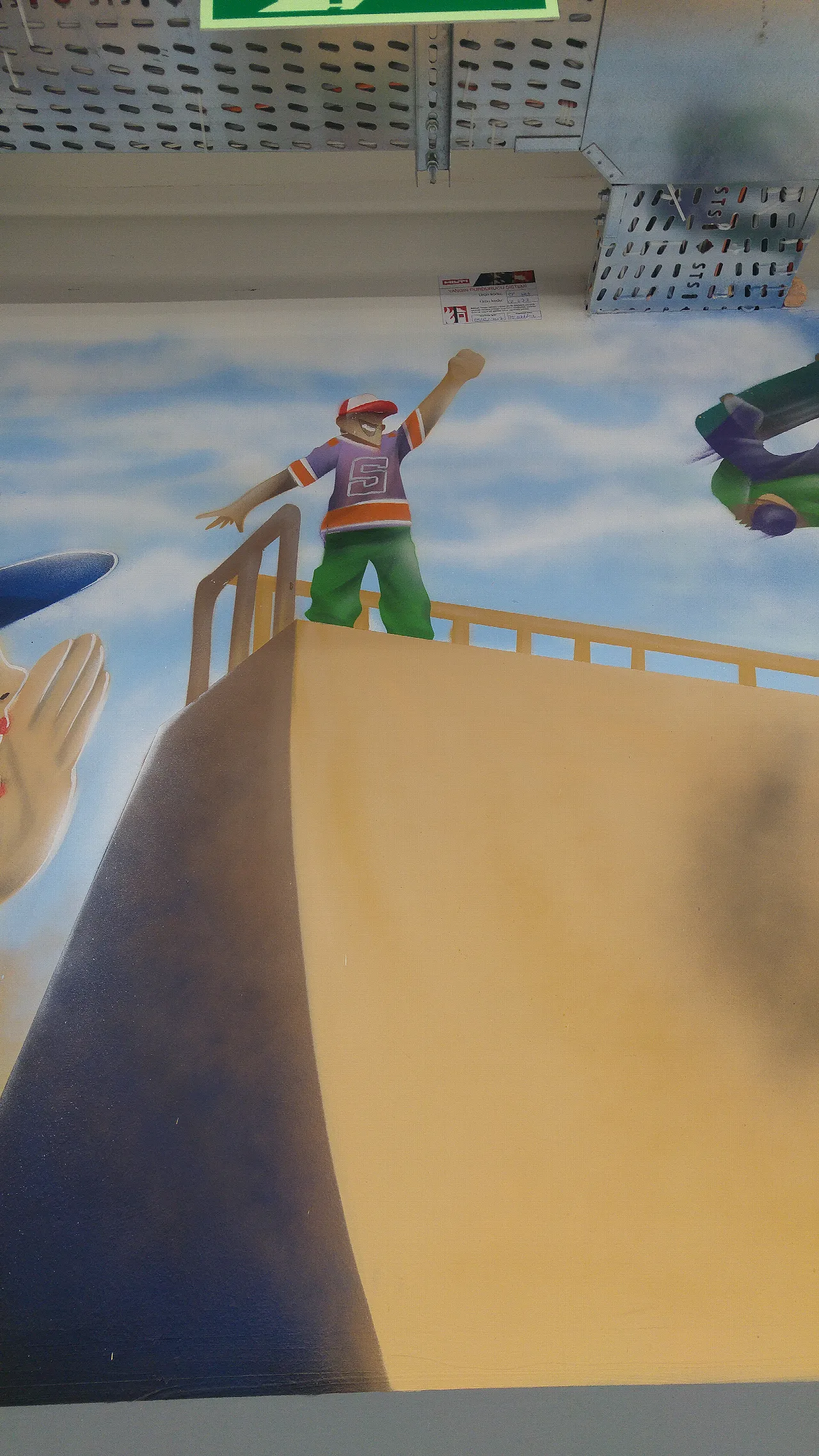 Mural of a child waving from a skateboard ramp